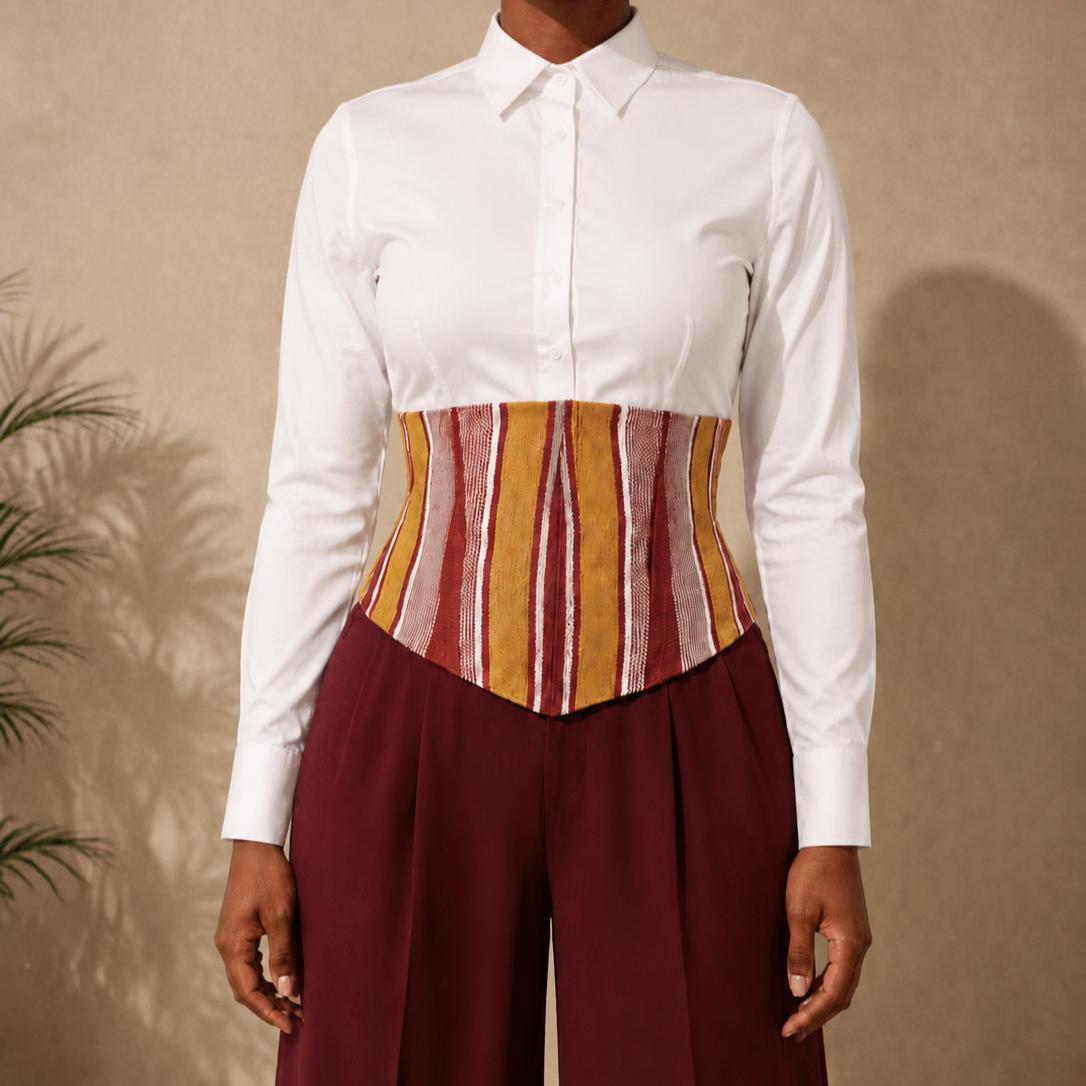 Mustard, burgundy and white Aso Oke corset belt worn over a white shirt
