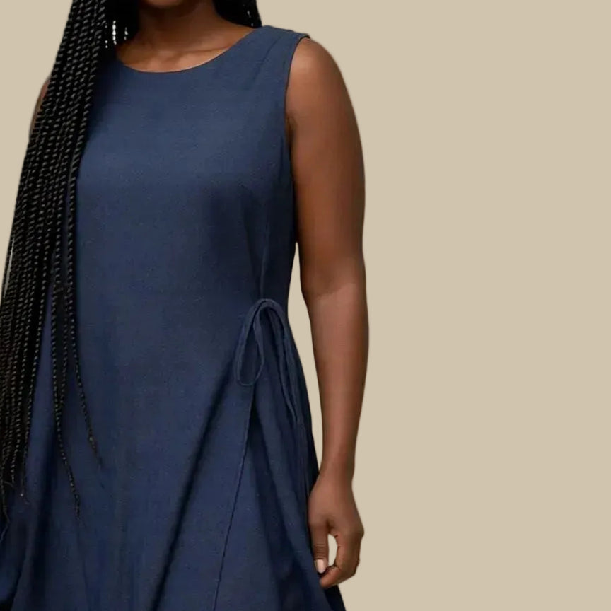 Woman wearing a navy blue dress against a plain background